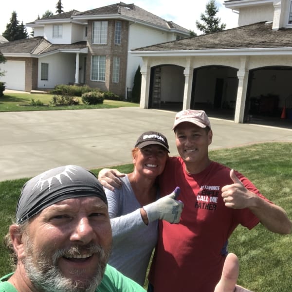 homeowner posing for a picture after resurfacing their driveway with alberta custom concrete